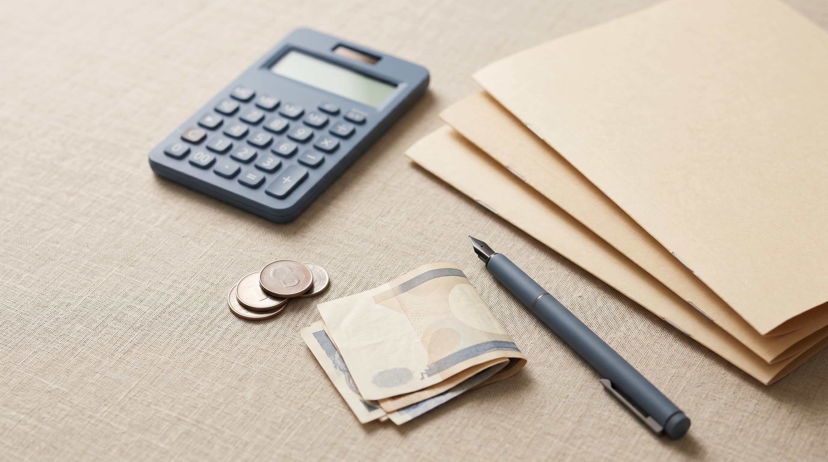 A calculator, plain document folders and coins on a desk illustrating the cost of Paraguay residency in 2026